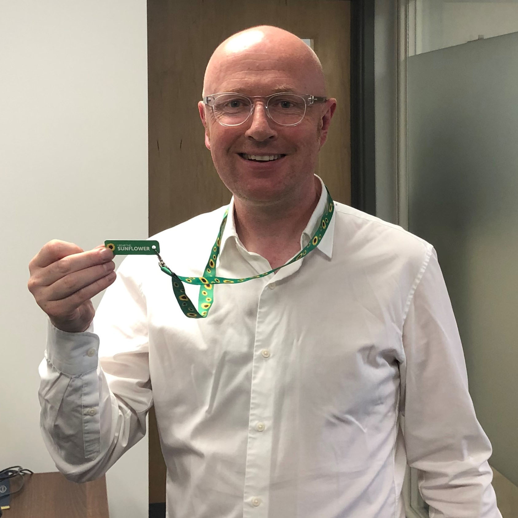 A member of staff showcasing the new 'sunflower' lanyard